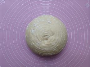 面团从发酵篮中倒出，放在揉面垫上进行整形