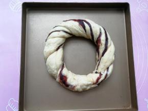 然后两手分别拉着面团的一端将两条面团反方向拧，拧成麻花状，最后圈成一个圈，两端相连处捏紧