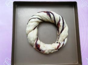 然后两手分别拉着面团的一端将两条面团反方向拧，拧成麻花状，最后圈成一个圈，两端相连处捏紧