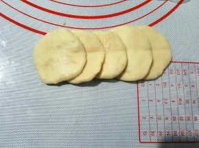 将面团擀成圆形面片，5个叠加，用筷子在中间压一下。