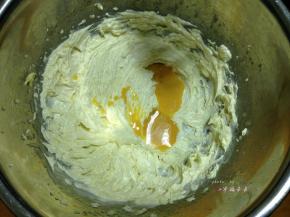 打至黄油颜色变浅成轻盈的羽毛状后分次加入全蛋液搅打均匀