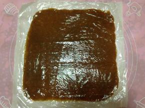 隔着保鲜膜用擀面杖把肉馅擀成和烤盘纸差不多大小的薄薄的片状，尽量擀得均匀