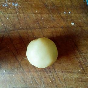 将饼皮按压后包入馅料