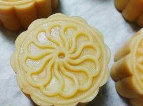 模具内撒防粘粉，将面团放入，按压成月饼，表面喷少许水，烤箱预热180度，5分钟后放入烤箱，烤5分钟后刷蛋黄液，再烤13分钟即可。