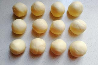 再把发酵好的面团取出来挤压排气，然后分成均匀的12个小面团滚圆，盖保鲜膜醒发15~20分钟左右；