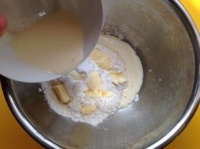 将低粉和糖粉、盐、小苏打混合拌匀，加入黄油，然后将酵母牛奶混合液倒入