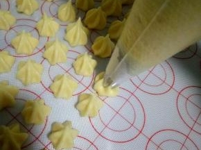 拌好的蛋白糊装入裱花袋，裱花袋和烤盘垂直开始挤豆豆吧
