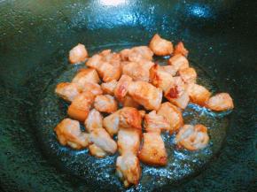 油中放入冰糖 倒入五花肉丁煸炒