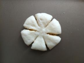 包好后收口朝下，按扁，用刮板切六刀，中间不切段