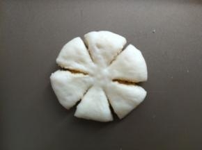 包好后收口朝下，按扁，用刮板切六刀，中间不切段