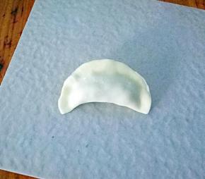 把面皮的一半用手指抹上一点水，然后两边对折。