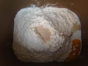 面团材料除黄油和盐，按照先液体后面粉，再加干酵母的顺序投入面包机搅拌桶，启动面包机和面