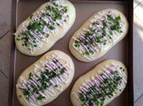 约40分钟后，面团二发完成，刷蛋液，放上培根，挤上沙拉酱，撒香葱碎