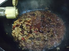 放入2勺的生抽，把肉末炒匀。