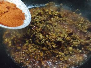 口蘑酱熬好后放入辣椒面，翻炒均匀。