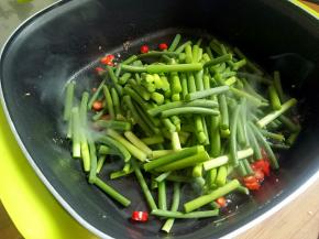 下蒜苔，炒至变色。