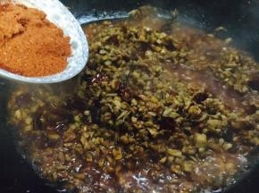 口蘑酱熬好后放入辣椒面，翻炒均匀。