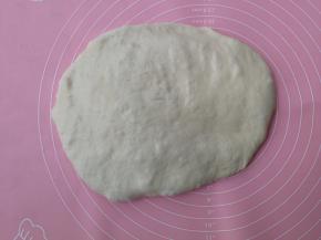 面团移至揉面垫上，按扁排气