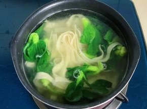 锅里放水煮面条和青菜