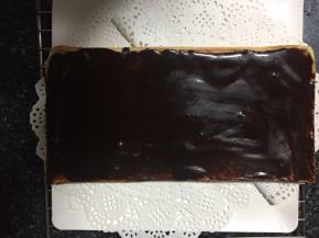 取一片蛋糕片，抹上甘纳许，然后放入冰箱冷藏。因为歌剧院蛋糕需要一层层叠高，所以甘纳许这一层要冻到巧克力层凝固。