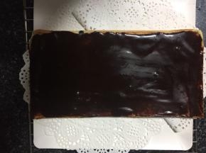 取一片蛋糕片，抹上甘纳许，然后放入冰箱冷藏。因为歌剧院蛋糕需要一层层叠高，所以甘纳许这一层要冻到巧克力层凝固。