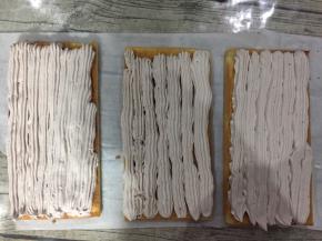 挑一个花嘴，均匀的将意式奶油霜均匀的挤到剩余的三片蛋糕片上。

用花嘴挤是为了让没有片上的奶油高度和质地都差不多，这样子切面才会好看。

挤好奶油霜后用抹刀抹平。