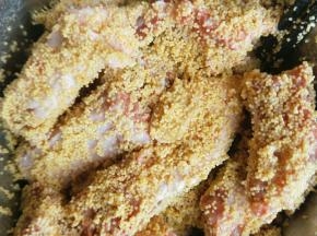 然后把小米倒入排骨中，让每一块排骨都裹上小米