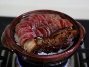 煮开后，当饭开始收水，可以看到饭表面有一个个的洞，就将切好的肉片码入。
