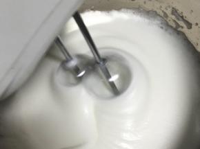 一边使用电动打蛋器打发蛋白，一边将烧好的糖水缓缓倒入蛋白中，每倒入一下都要马上将打蛋头高速打散糖水，不倒入的时候就低速确保打发。

注意不要将糖水沿着盆壁倒或者直接倒在打蛋头上，糖水遇冷会马上凝结在上面，无法融入蛋白霜。
