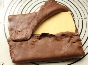 冻过的面团，和黄油保持一个硬度，擀大，把黄油片包在里面，边缘捏紧。