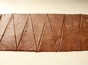 切去边缘，如果做可颂，就分割成底边8厘米左右的等腰三角形，如果做脏脏包，分割就不用那么精细，大致是梯形的面片即可。