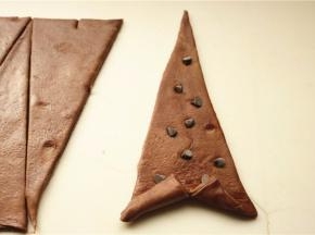 做可颂，等腰三角形底部再切开一个口子，向两边拉着卷上去，巧克力豆可以这个时候卷进去，记得按一下。