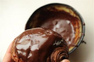 黑巧克力加少许牛奶和白砂糖，隔热水融化成巧克力酱，把可颂在里面蘸一下，使表面裹满巧克力酱。