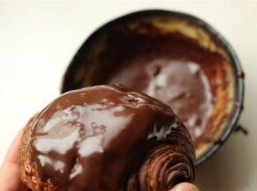 黑巧克力加少许牛奶和白砂糖，隔热水融化成巧克力酱，把可颂在里面蘸一下，使表面裹满巧克力酱。