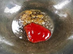 倒出锅中的油，留底油，放入白糖搅拌至融化后，加入香醋和番茄沙司拌匀