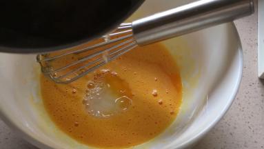 两个蛋黄打散，将砂糖水缓慢倒入