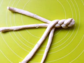 再将4搭在1、3之间，将1拿起搭在2、3之间，这样编完，数字又改变成最初的1234，之后再重复之前的步骤，将2搭在3上，扭成麻花