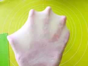 这时候的面团已经不粘手，表面也比较光滑，切下一小块用手一点点撑开，可以撑出有弹性的薄薄手套膜即可