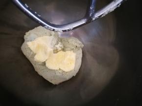 面团打到光滑成团后，加入软化的黄油