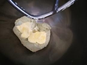 面团打到光滑成团后，加入软化的黄油