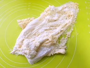 加入牛奶和成棉絮状，之后倒在揉面垫上，取出酵头面团一起推揉