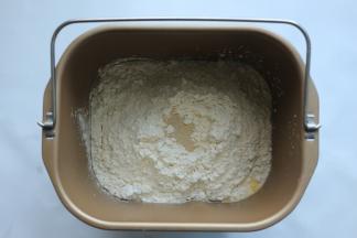 除黄油外，将所有材料放入面包机拌桶里，在面粉表面挖个洞放入酵母