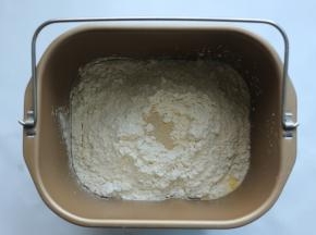 除黄油外，将所有材料放入面包机拌桶里，在面粉表面挖个洞放入酵母