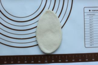 取一个小面团，用擀面杖擀成舌形