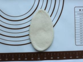 取一个小面团，用擀面杖擀成舌形