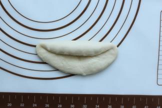 然后翻面过来，由上往下卷到小面团的中间