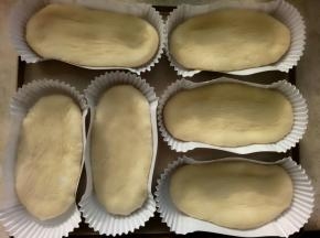 醒好以后擀成牛舌形放入纸托里。有发酵箱的36度进行第二次发酵(60-90分钟左右)。没有发酵箱的可以放入烤箱里面放入一碗热水。