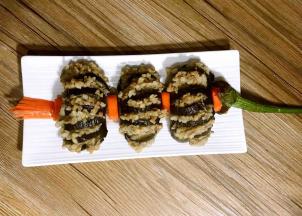 摆入盘中，再将腌制好的红萝卜切的灯笼须和灯笼口摆在上、中、下，再将茄子蒂摆在灯笼的上端