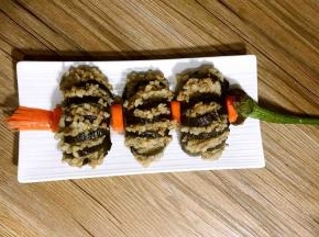 摆入盘中，再将腌制好的红萝卜切的灯笼须和灯笼口摆在上、中、下，再将茄子蒂摆在灯笼的上端