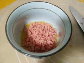 火腿肠碎加入鸡蛋，拌匀